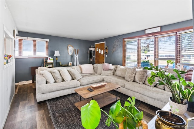 living area featuring dark wood-style flooring and a healthy amount of sunlight