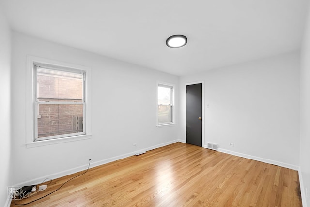 unfurnished room with baseboards, light wood-style floors, and visible vents