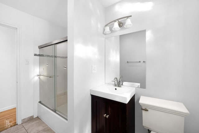 bathroom featuring enclosed tub / shower combo, toilet, and vanity