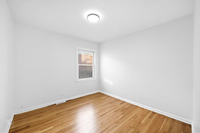 spare room featuring visible vents, baseboards, and light wood-style floors