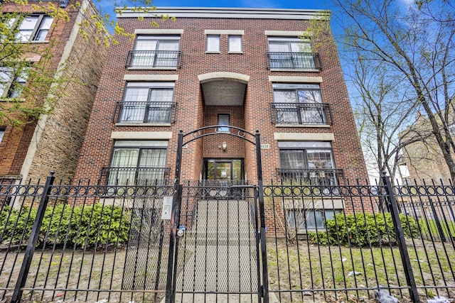 4538 S Calumet Ave Unit 3N, Chicago, IL 60653 - view of front facade with a fenced front yard, a gate, and brick siding