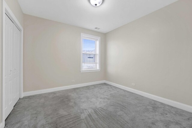 4538 S Calumet Ave Unit 3N, Chicago, IL 60653 - unfurnished bedroom featuring a closet, visible vents, carpet, and baseboards