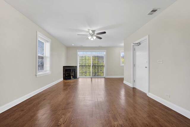 4538 S Calumet Ave Unit 3N, Chicago, IL 60653 - unfurnished living room featuring visible vents, baseboards, dark wood finished floors, a fireplace, and a ceiling fan