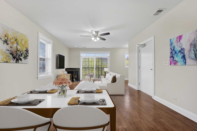4538 S Calumet Ave Unit 3N, Chicago, IL 60653 - dining area featuring dark wood-style flooring, a fireplace, ceiling fan, visible vents, and baseboards