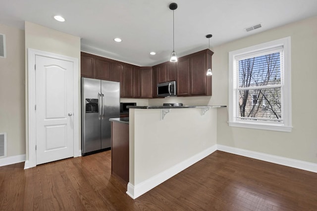 4538 S Calumet Ave Unit 3N, Chicago, IL 60653 - kitchen featuring a breakfast bar area, appliances with stainless steel finishes, dark wood-style floors, baseboards, and a peninsula