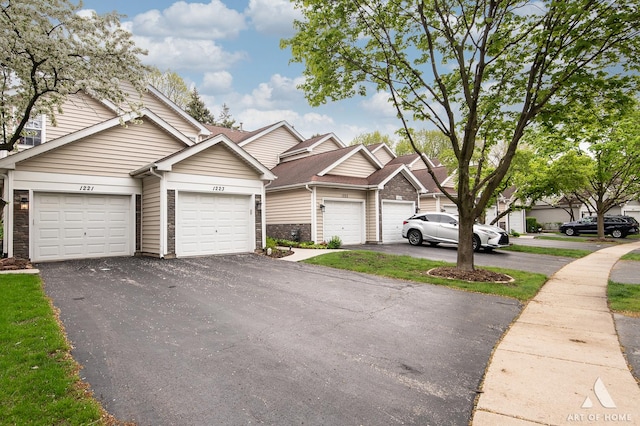 view of property with asphalt driveway and stone siding