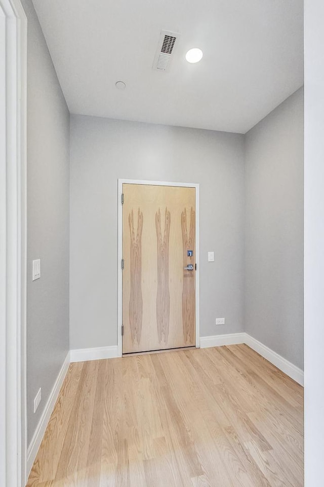 spare room featuring visible vents, baseboards, and wood finished floors