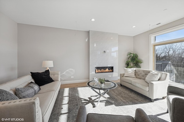 living area featuring recessed lighting, a tile fireplace, wood finished floors, visible vents, and baseboards