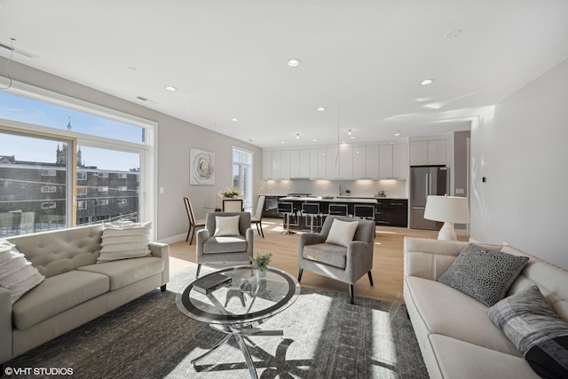 living room with recessed lighting and light wood-style flooring