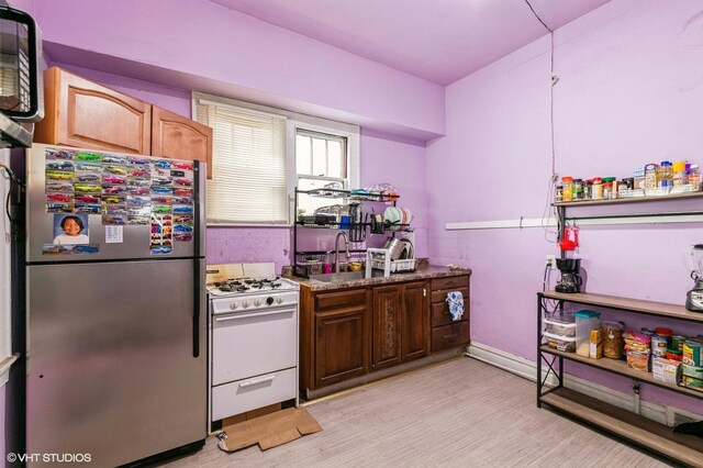 8119 S Escanaba Ave, Chicago, IL 60617 - kitchen with freestanding refrigerator, white gas stove, and light wood-type flooring
