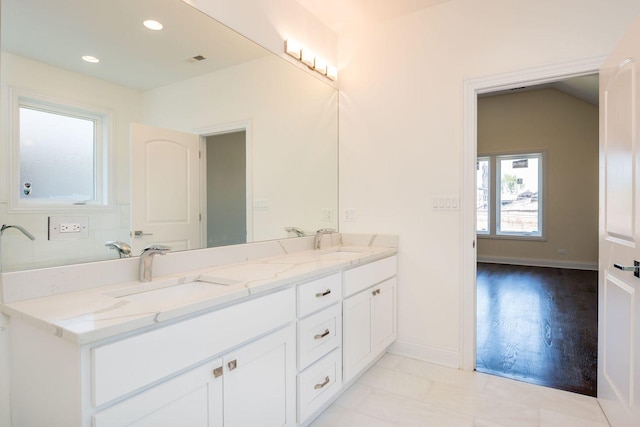 full bath with baseboards, a sink, recessed lighting, and double vanity