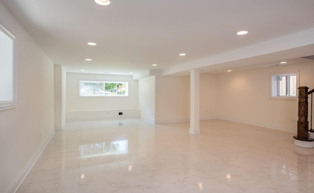 basement with recessed lighting, marble finish floor, and baseboards