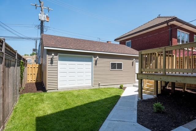 view of yard featuring a garage, a fenced backyard, and a deck