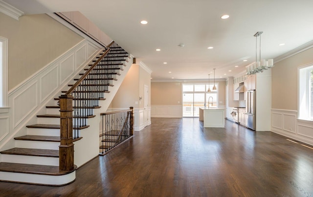 interior space featuring a healthy amount of sunlight, ornamental molding, and a decorative wall