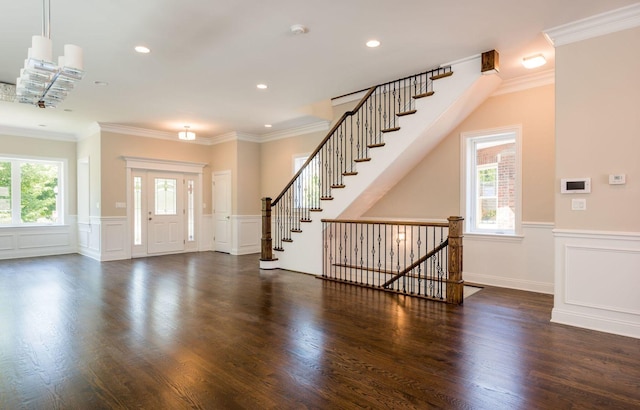 foyer entrance with wood finished floors, a decorative wall, and a wainscoted wall