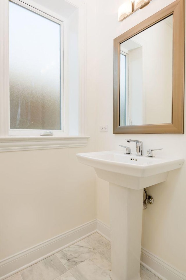 bathroom featuring marble finish floor and baseboards