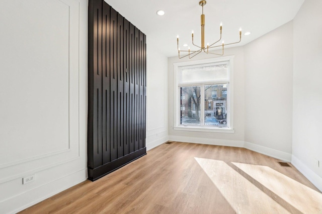 interior space featuring recessed lighting, baseboards, an inviting chandelier, and light wood-style flooring