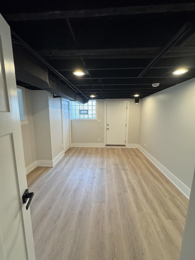basement featuring light wood-type flooring and baseboards