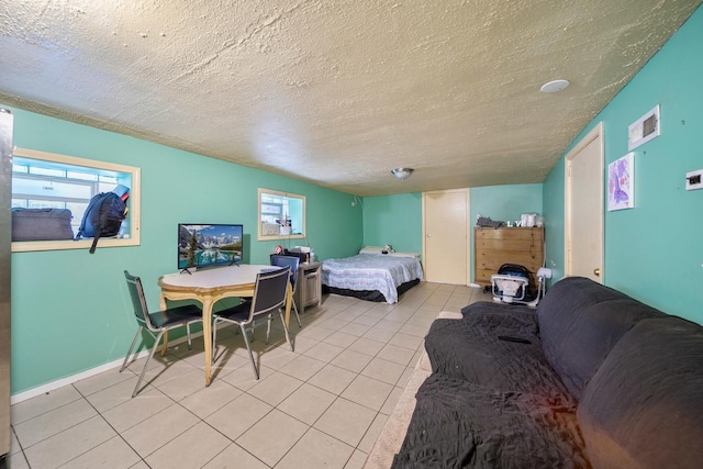 bedroom featuring visible vents, a textured ceiling, multiple windows, and light tile patterned floors