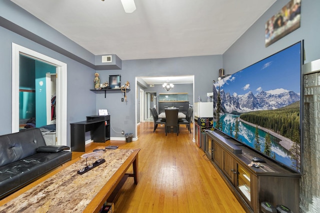 living area with a chandelier, light wood-style flooring, and visible vents