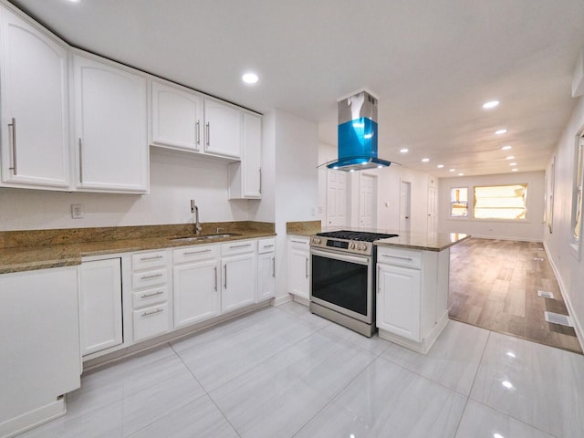 14923 Wood St, Harvey, IL 60426 - kitchen with white cabinets, stainless steel range with gas cooktop, a peninsula, a sink, and island range hood