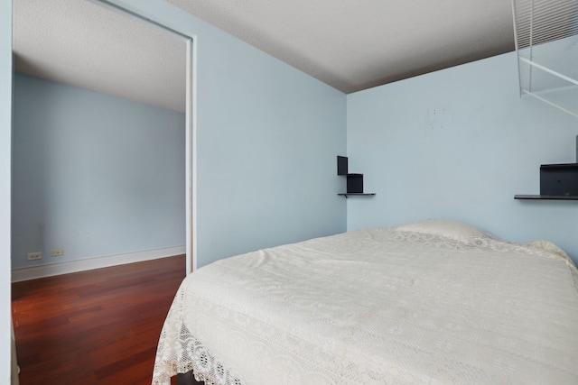 bedroom featuring baseboards, a closet, and wood finished floors