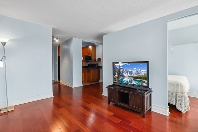 living area with baseboards and dark wood finished floors