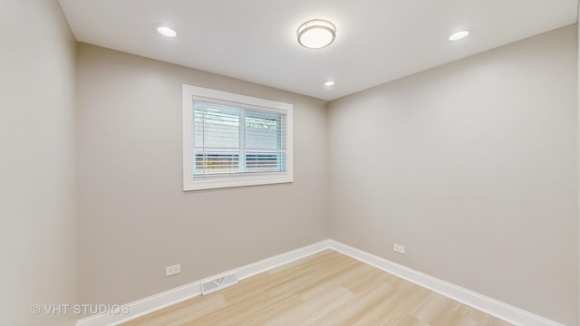 spare room featuring light wood-style floors, baseboards, recessed lighting, and visible vents