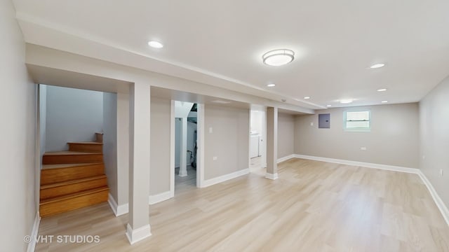 basement with stairs, light wood-style floors, baseboards, recessed lighting, and electric panel