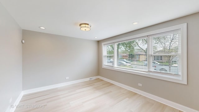 unfurnished room with recessed lighting, baseboards, visible vents, and light wood finished floors