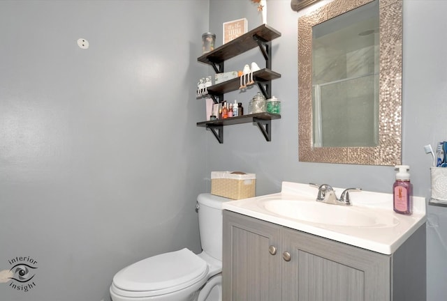 bathroom with vanity, a shower, and toilet