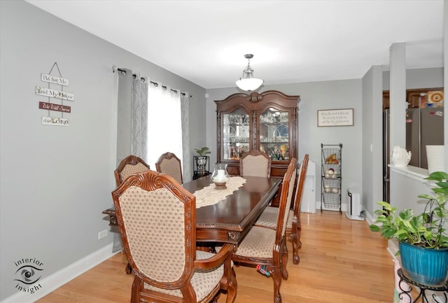 dining space featuring light wood-style floors and baseboards