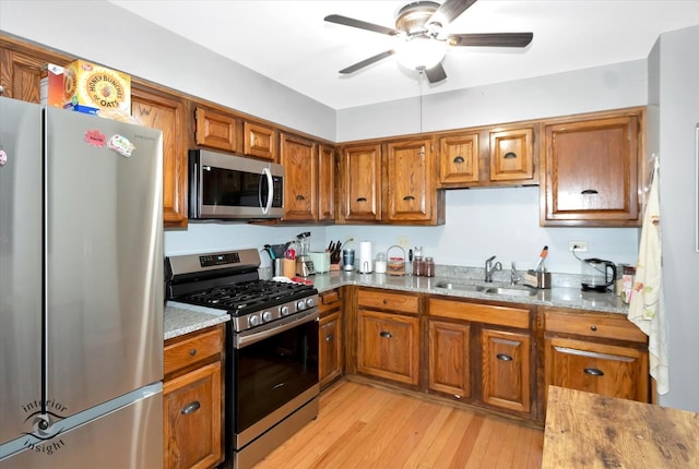 kitchen featuring a sink, ceiling fan, brown cabinets, and stainless steel appliances