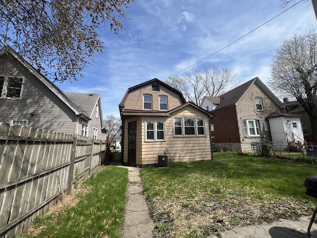 11916 S Harvard Ave, Chicago, IL 60628 - back of house with a lawn, a gambrel roof, central AC, and a fenced backyard