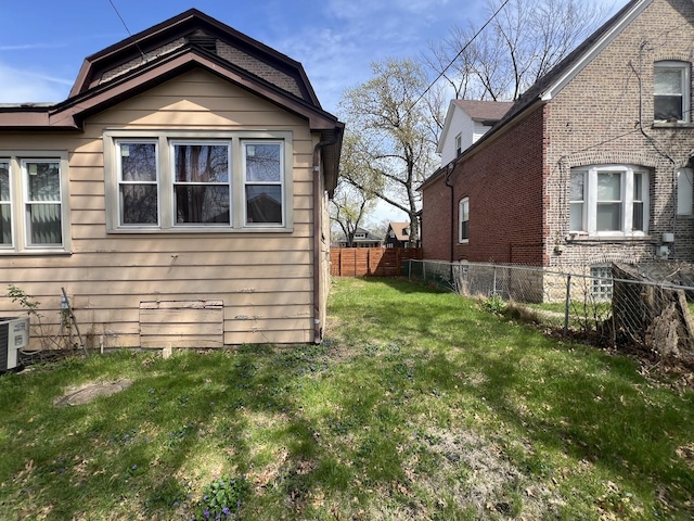 11916 S Harvard Ave, Chicago, IL 60628 - view of side of home featuring fence, cooling unit, and a lawn