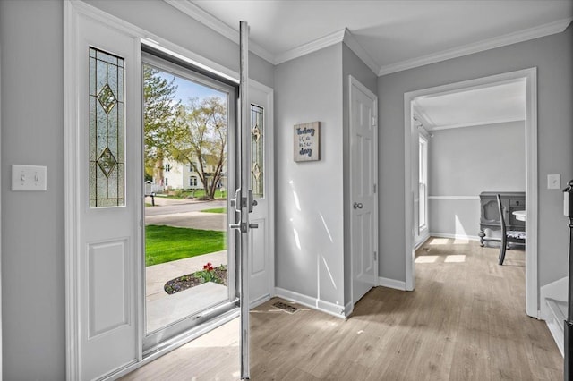 foyer entrance featuring baseboards, ornamental molding, and wood finished floors