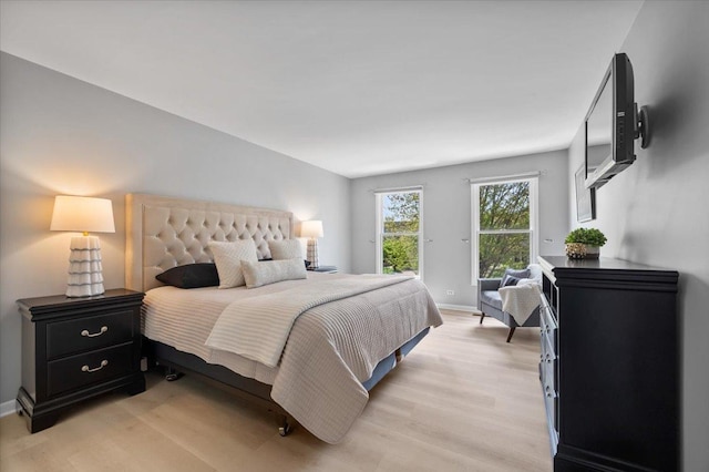 bedroom with light wood-type flooring and baseboards