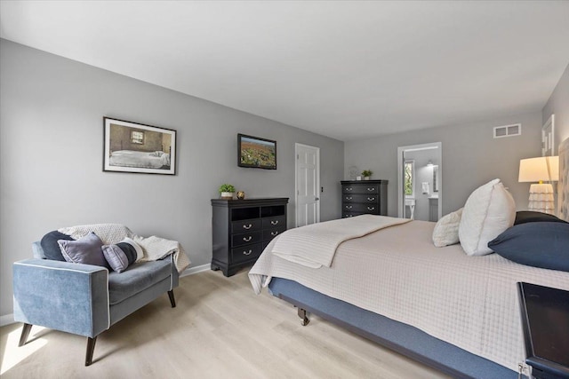 bedroom featuring visible vents, connected bathroom, baseboards, and light wood-type flooring