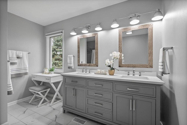 full bath featuring double vanity, a sink, and marble finish floor