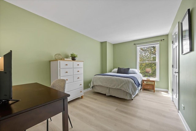 bedroom with baseboards and light wood-type flooring