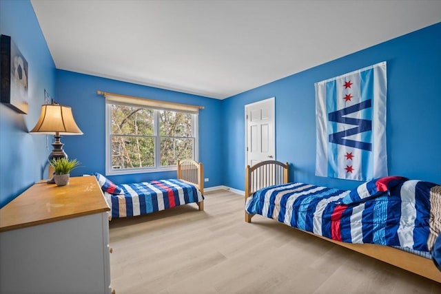 bedroom featuring baseboards and wood finished floors
