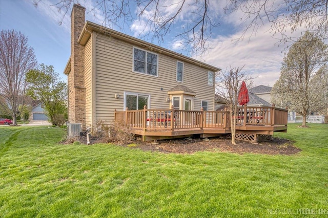 back of property with central air condition unit, a chimney, a lawn, and a deck