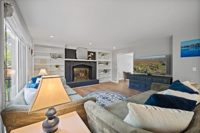 living room with a fireplace, recessed lighting, and wood finished floors