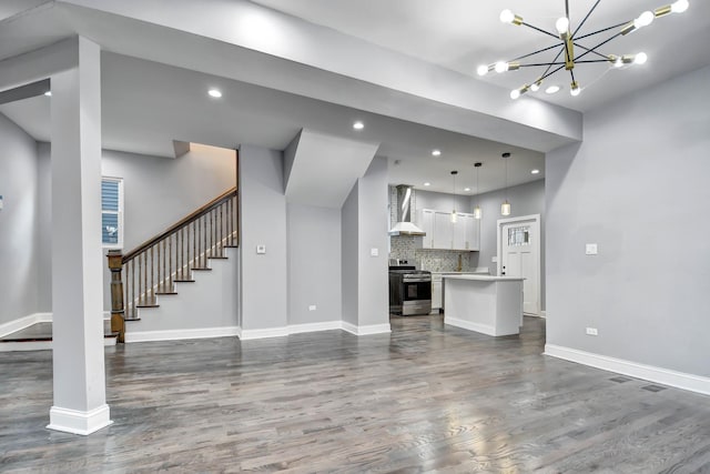 unfurnished living room featuring dark wood-type flooring, a chandelier, baseboards, and recessed lighting