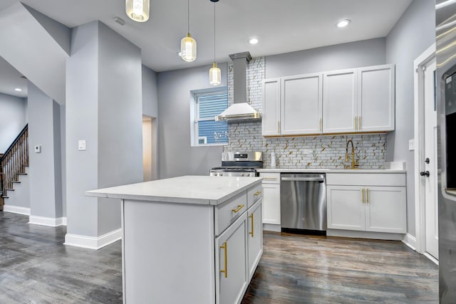 kitchen with light countertops, wall chimney range hood, tasteful backsplash, appliances with stainless steel finishes, and dark wood-style flooring