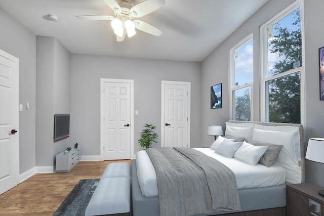 bedroom with baseboards, a ceiling fan, and wood finished floors