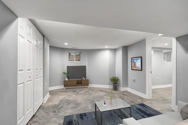 living room with baseboards, concrete flooring, and recessed lighting