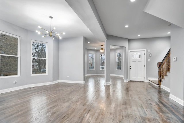 foyer entrance with baseboards, an inviting chandelier, recessed lighting, wood finished floors, and stairway