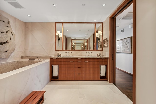 full bath featuring double vanity, a sink, visible vents, and recessed lighting