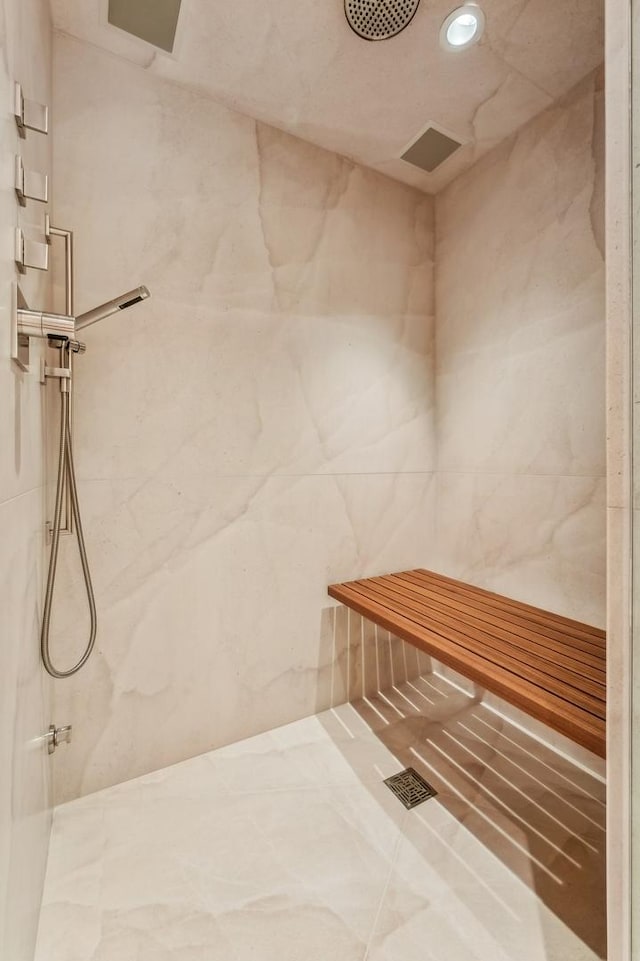full bath featuring recessed lighting, tile walls, and a marble finish shower